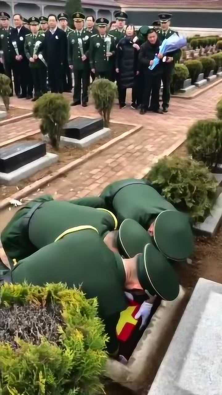 王成龙烈士的骨灰盒上面覆盖着鲜艳的国旗英雄入土为安敬礼