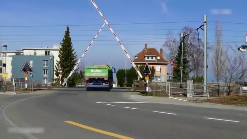 铁路交叉口,栏杆都快放下来了,卡车还要通过去