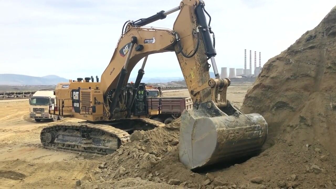 采矿公司用卡特彼勒挖掘机6015b装载卡车