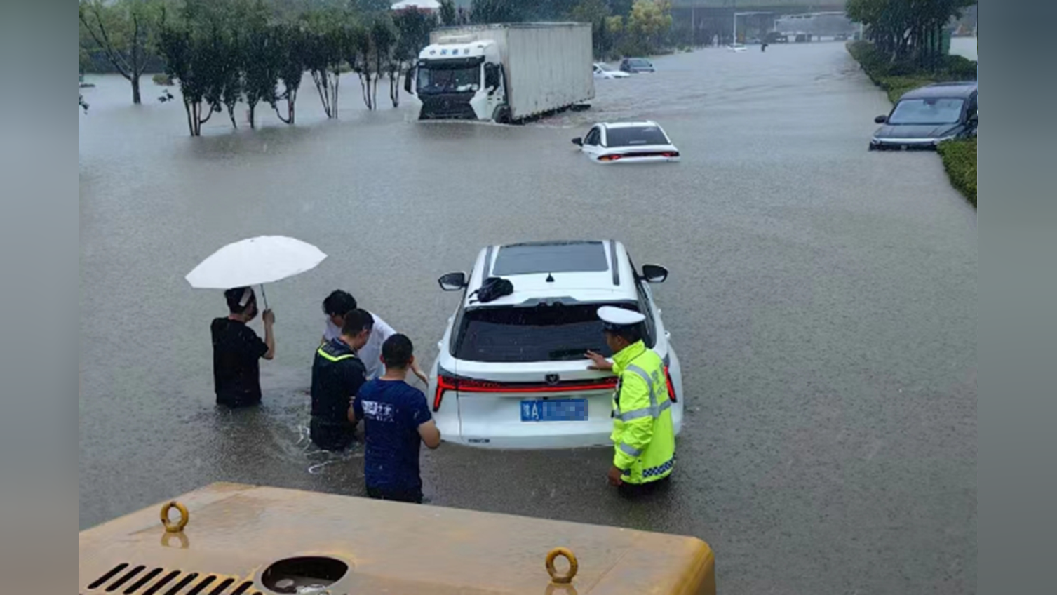 郑州持续降雨,汽车陷入花坛,应急救援队救出多辆汽车