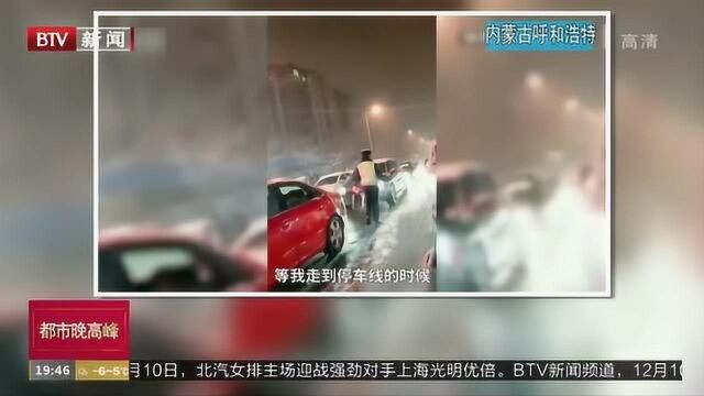 内蒙古呼和浩特:大雪天 辅警为过往车辆除积雪