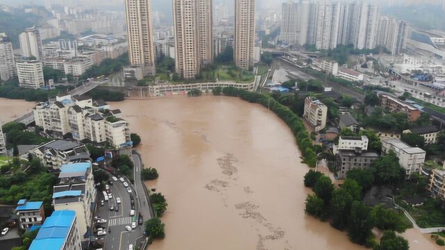 航拍重庆綦江特大洪峰过境:滨江洼地成汪洋 小车艰难“划水”前行