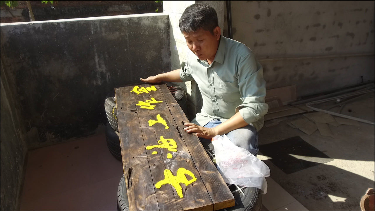 用最原始的火烧手法将破旧废门板自制成工作室牌匾