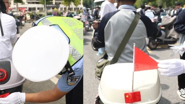 交警为骑行市民贴反光车贴,中国红点亮回家的路:被看见才安全