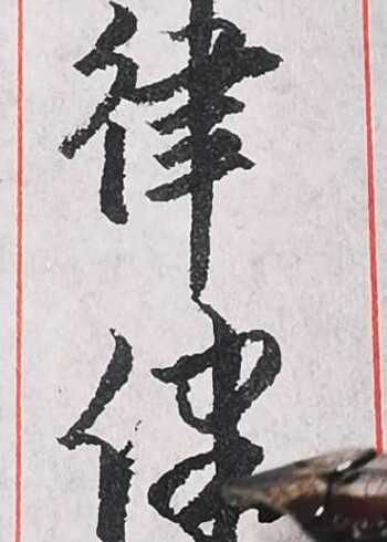 "律"字其中的两种行书和草书写法.