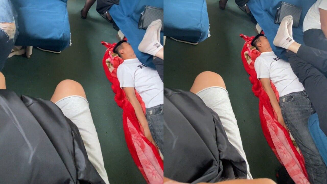 男子旅途太疲惫,躺火车座位底下睡觉,睡醒后淡定躺着玩手机