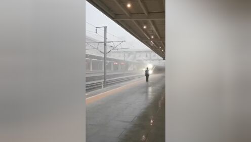 坚守的背影！汉中火车站一名工作人员在暴雨中迎接火车进站