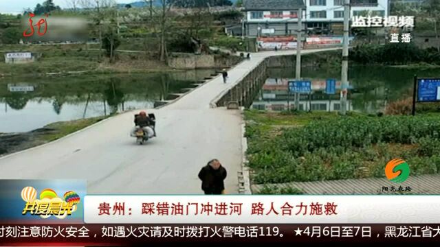 贵州:踩错油门冲进河 路人合力施救