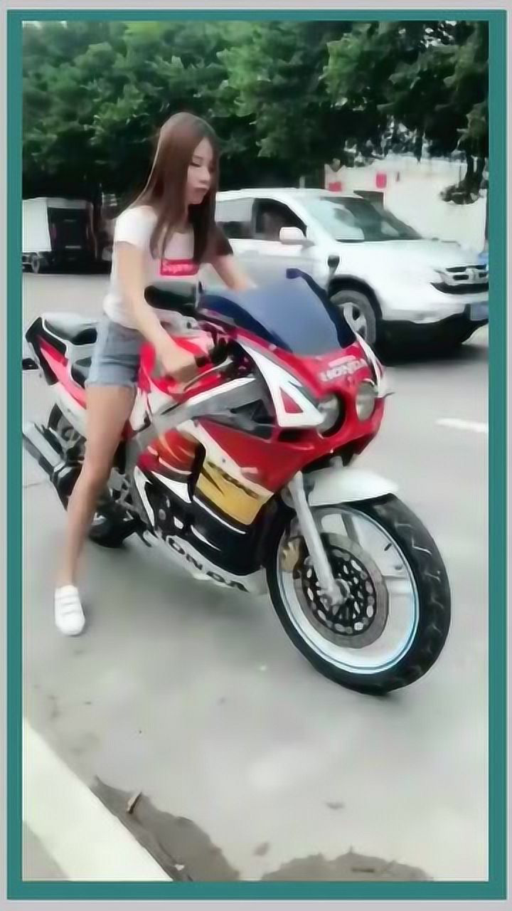 这个漂亮的机车妹子坐在摩托车上一直轰油门