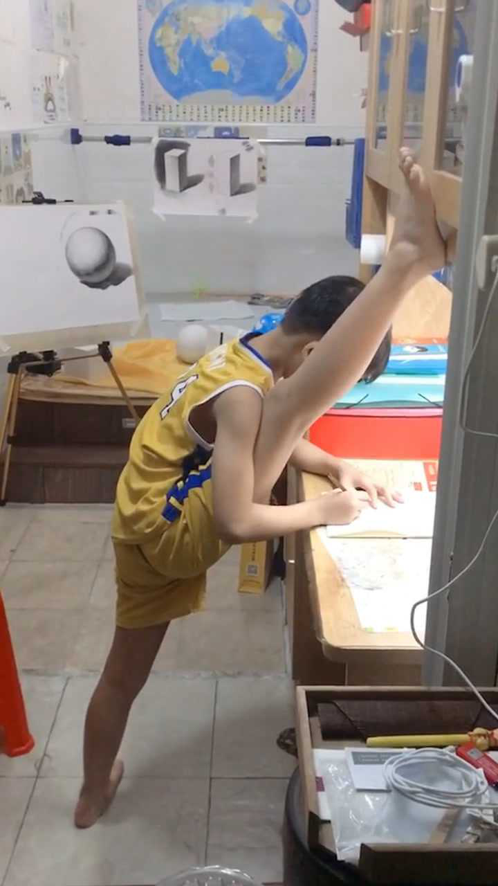 男孩边写作业边一字马劈叉 姿势惊奇看得人目瞪口呆