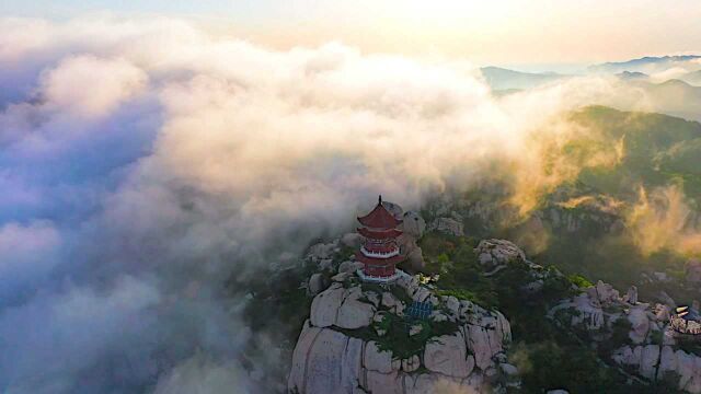 航拍山东日照九仙山云海,日落时分山峦似披上金色薄纱