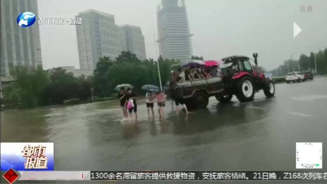 新乡暴雨:新乡学院门口,拖拉机救人!