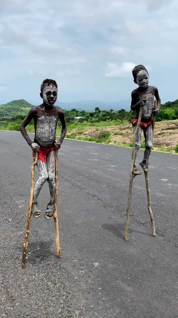 原始部落的斑马族,一群孩子踩高跷在马路上,看着很吓人!