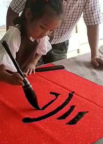 小孙女七岁了,爷爷教孙女写毛笔字,孙女字写得真好