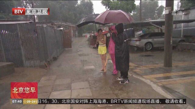 石景山区迎强降雨,社区人员为平房区居民排忧解难