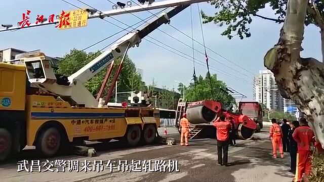 武珞路,一台轧路机掉下平板运输车,目前已被吊起