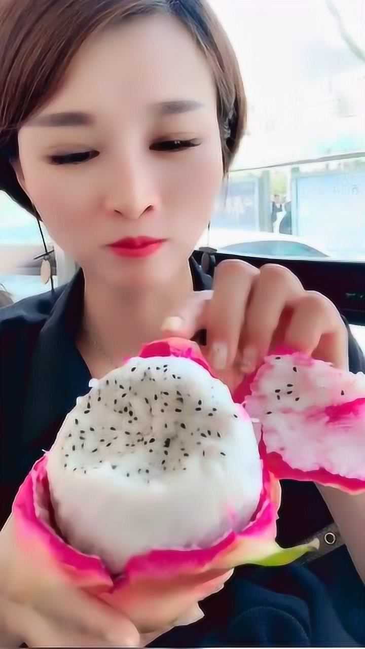 小姐姐在公交车上吃火龙果,大口咬着吃,一点不注意形象