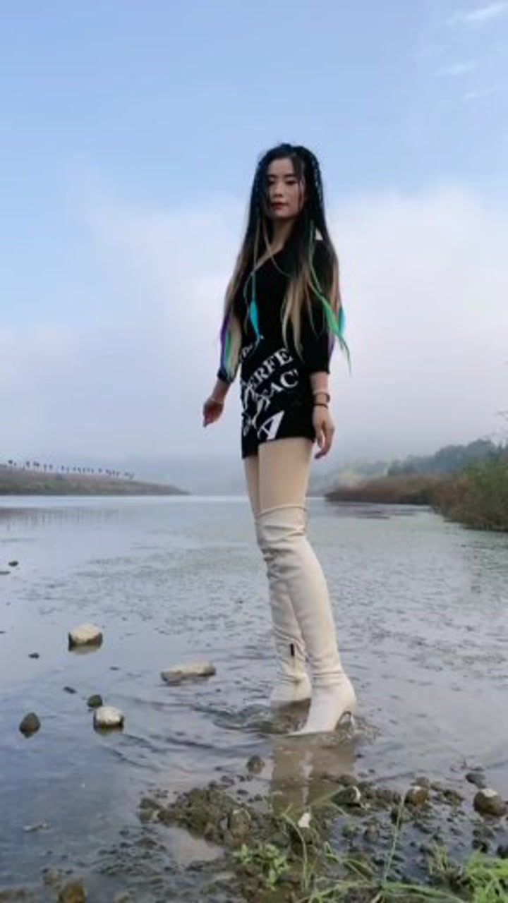 这女朋友真顽皮穿上高跟长靴玩起水来了像一个没长大的孩子