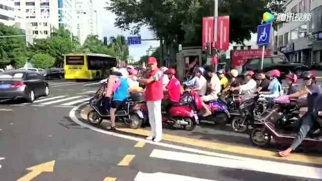 街拍海口六旬候鸟老人用生命在指挥交通