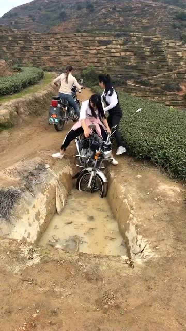 农村的路太窄了美女骑着摩托车躲避对面的车竟然掉沟里了