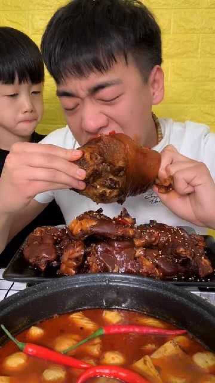 小伙吃猪肘子这吃相太馋人了旁边孩子的反应可爱了忍住别笑