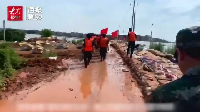 鄱阳县昌江水面已高过河岸 武警战士连夜搬沙袋筑高河堤