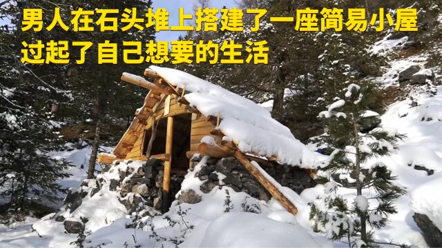 男人在石头堆上搭建了一座简易小屋,过起了自己想要的生活