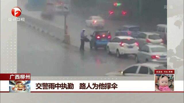 广西柳州 交警雨中执勤 路人为他撑伞