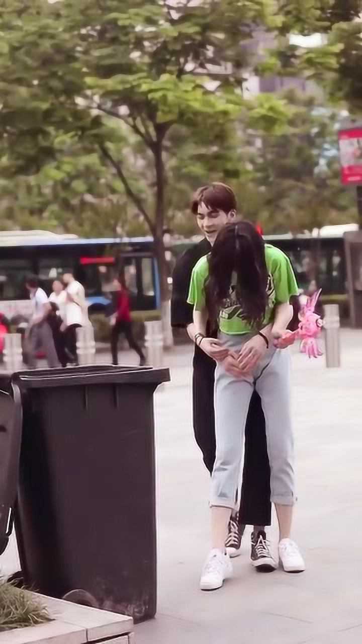 街拍到一对小情侣帅哥从后面抱起美女却不小心把她弄疼了
