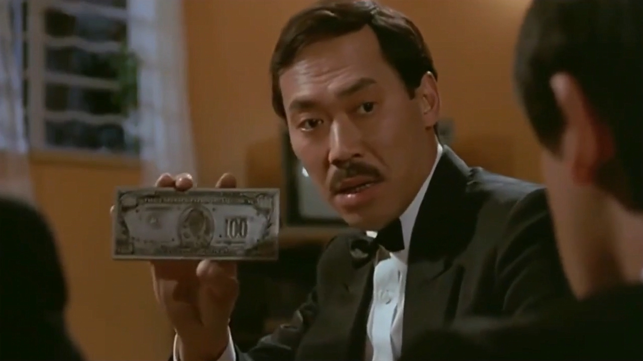 洪金宝打开箱子,里面放满了美金,冯淬帆一看就知是假钞