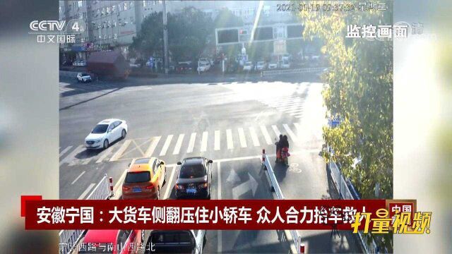 安徽宁国:大货车侧翻压住小轿车,众人合力抬车救人