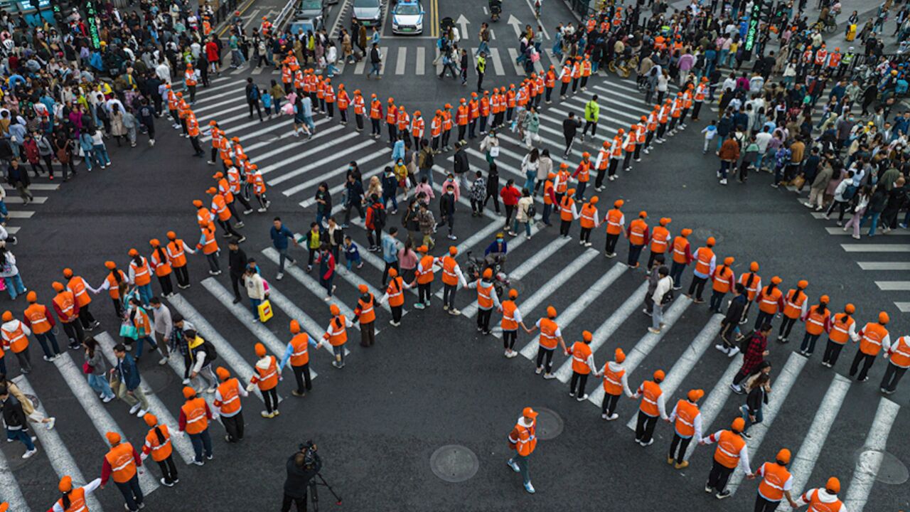 五一假期西湖边人潮涌动 街头人墙筑起"x"型斑马线引导游客