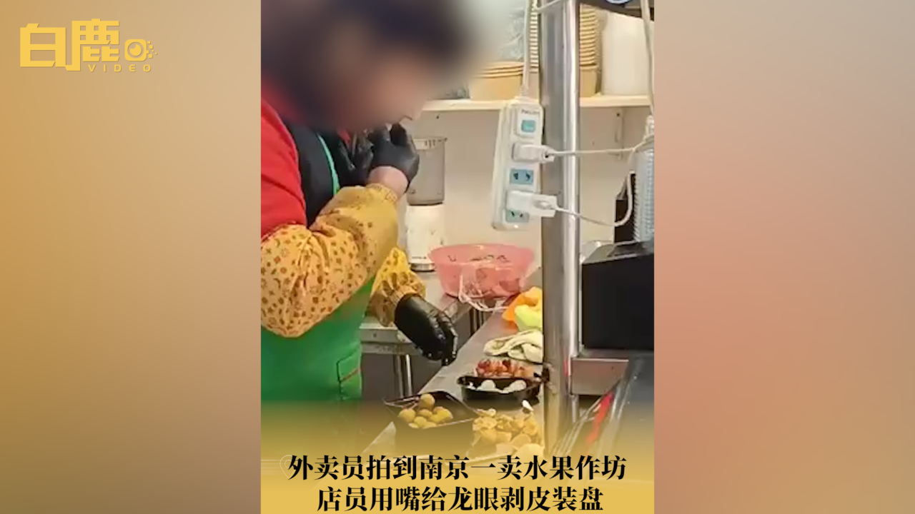南京一水果店家用嘴给龙眼剥皮